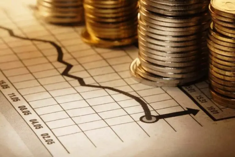 Gráfico econômico mostrando crescimento financeiro com pilhas de moedas ao lado, representando planejamento e investimentos seguros, como o consórcio.